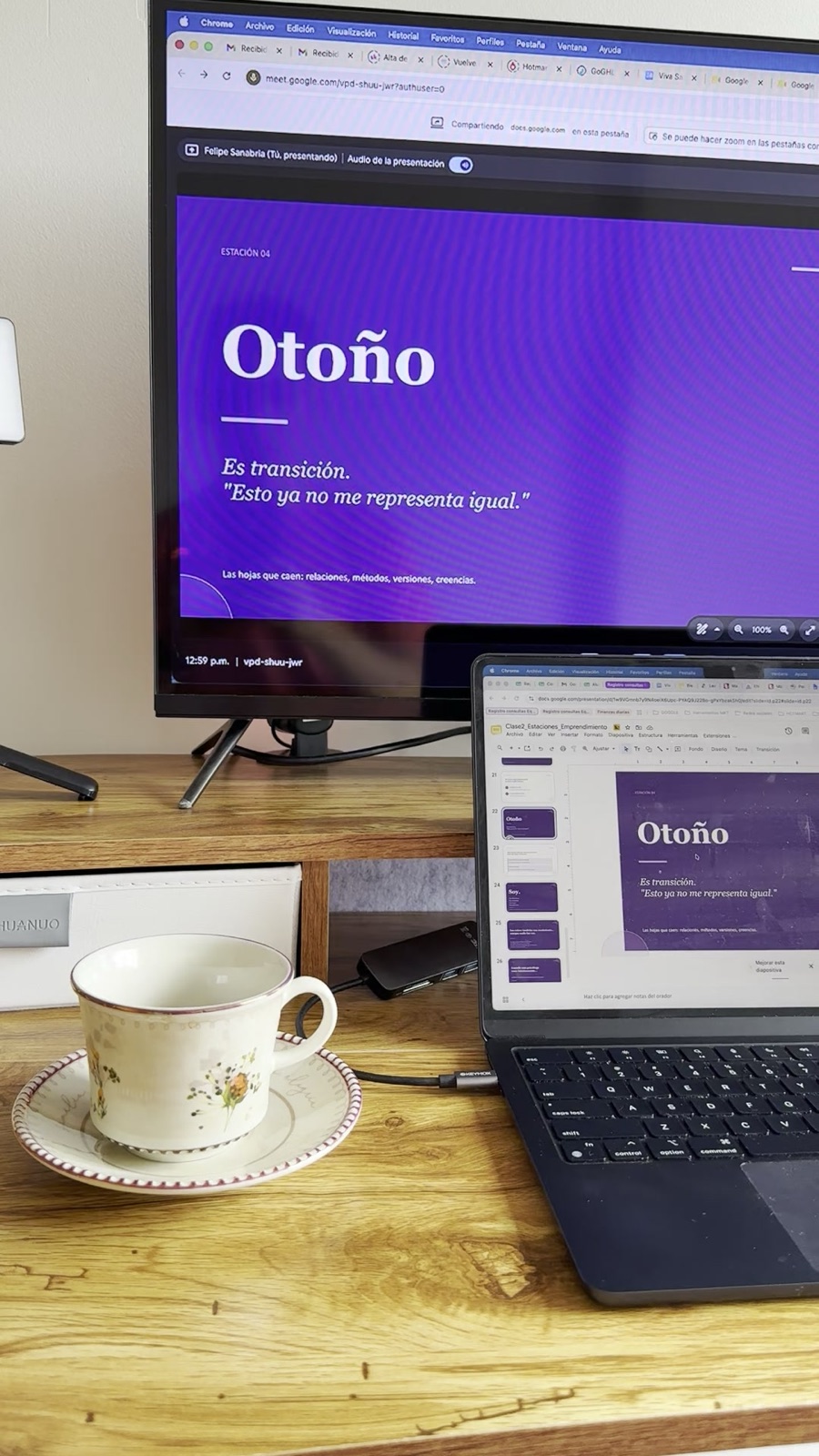 Espacio de trabajo en casa con una presentación en pantalla, un portátil y una taza